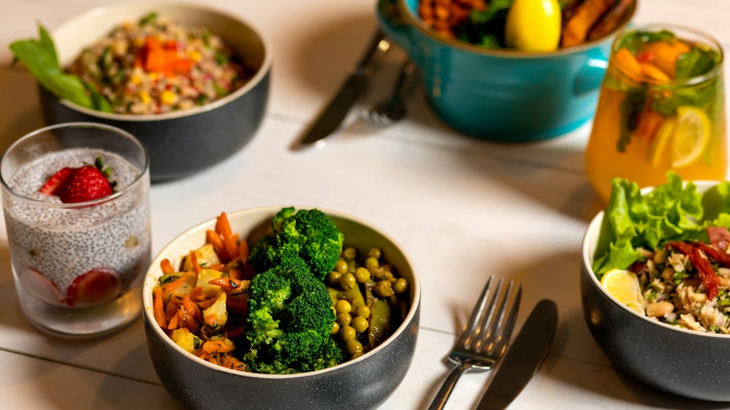 Colorful plant-based meals and drinks on a rustic table.