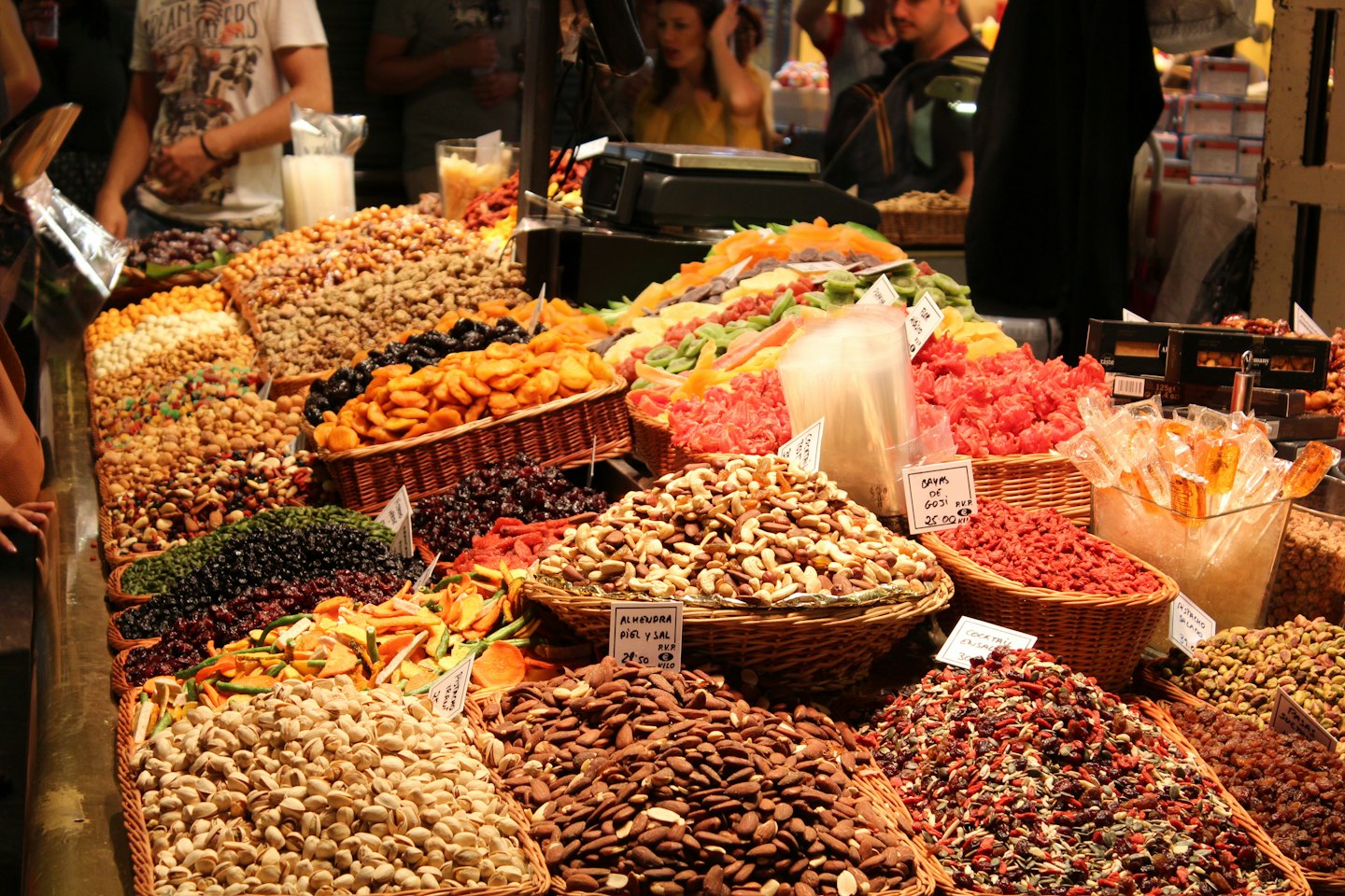 Market stall overflowing with nuts, dried fruits, and candies.